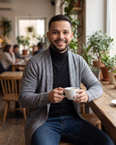 Homem num café com o cardigã cinza (imagem criada com IA)