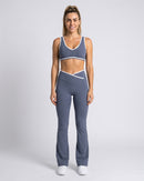 Conjunto top e calça flare azul acinzentado de corpo inteiro, de frente (imagem criada com IA)