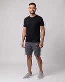 Homem de camiseta preta e bermuda usando o Tênis Air Flow cinza (imagem criada com IA)
