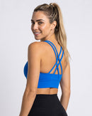 Top Fitness Costas Cruzadas azul elétrico visto de costas, com as alças cruzadas em X (imagem criada com IA)
